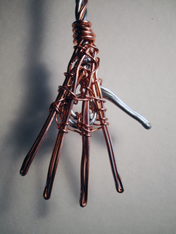 The hand is a combination of 16 gauge aluminum for the thumb and 18 gauge copper wire for the fingers secured to an aluminum wire coil with 24 gauge copper wire.